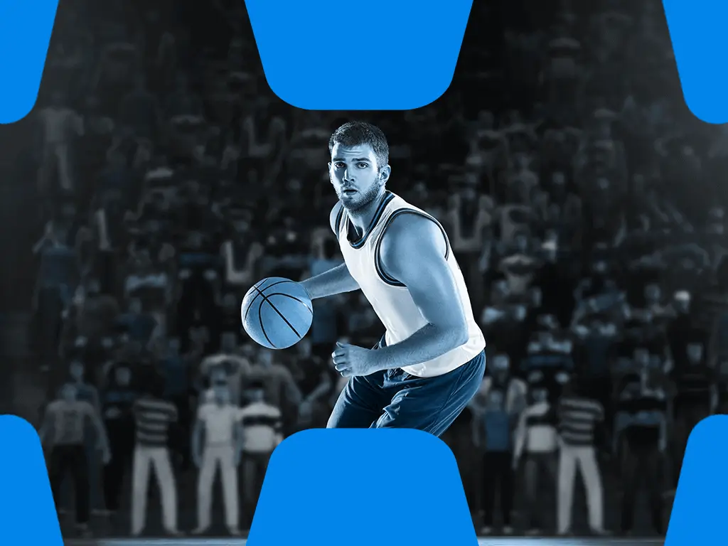 Basketball Spieler haelt Basketball in der Hand vor Publikum